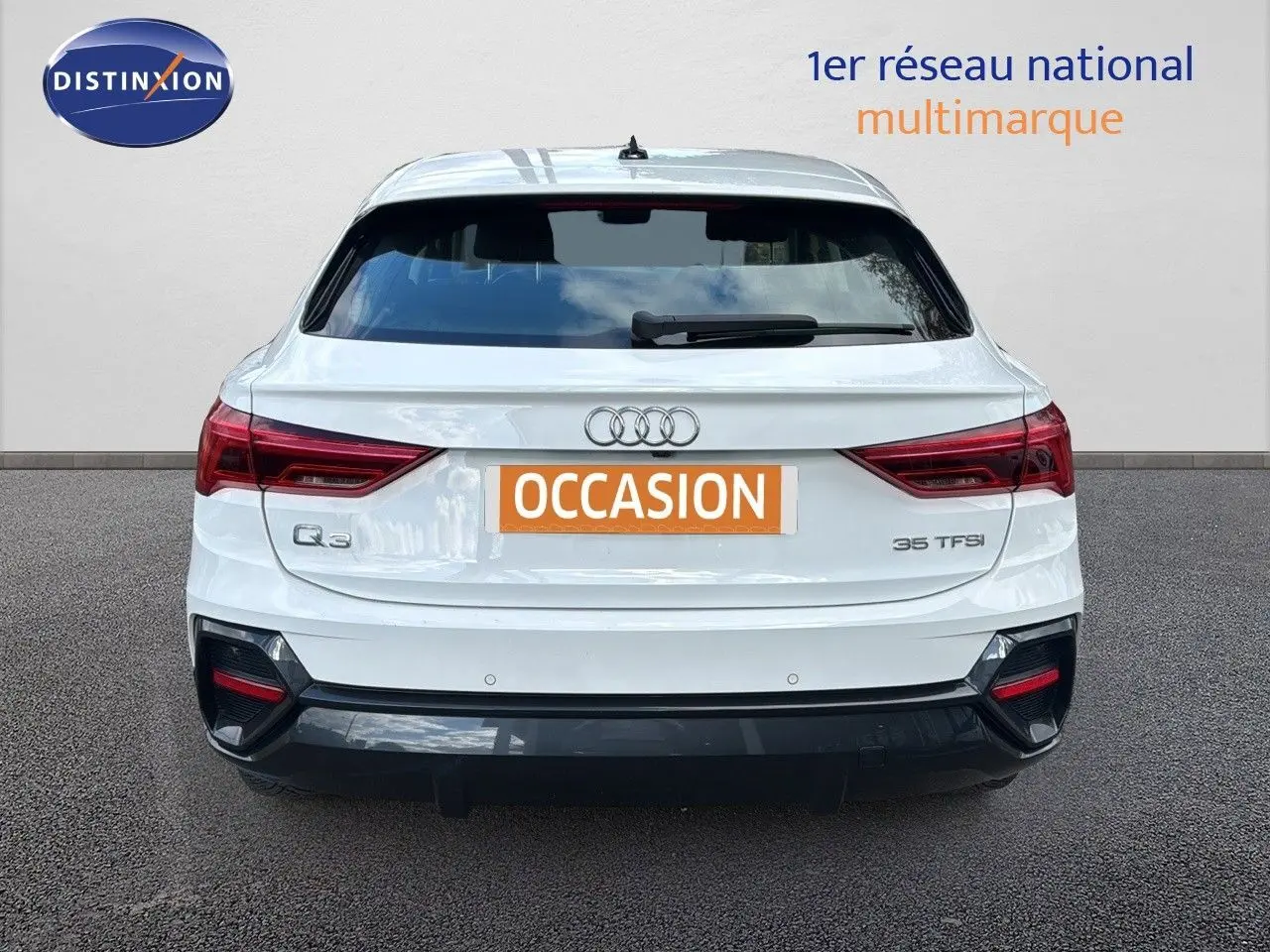 Vue arrière d'un Audi Q3 Sportback blanc de 2021 avec feux rouges et logo Audi bien visibles.