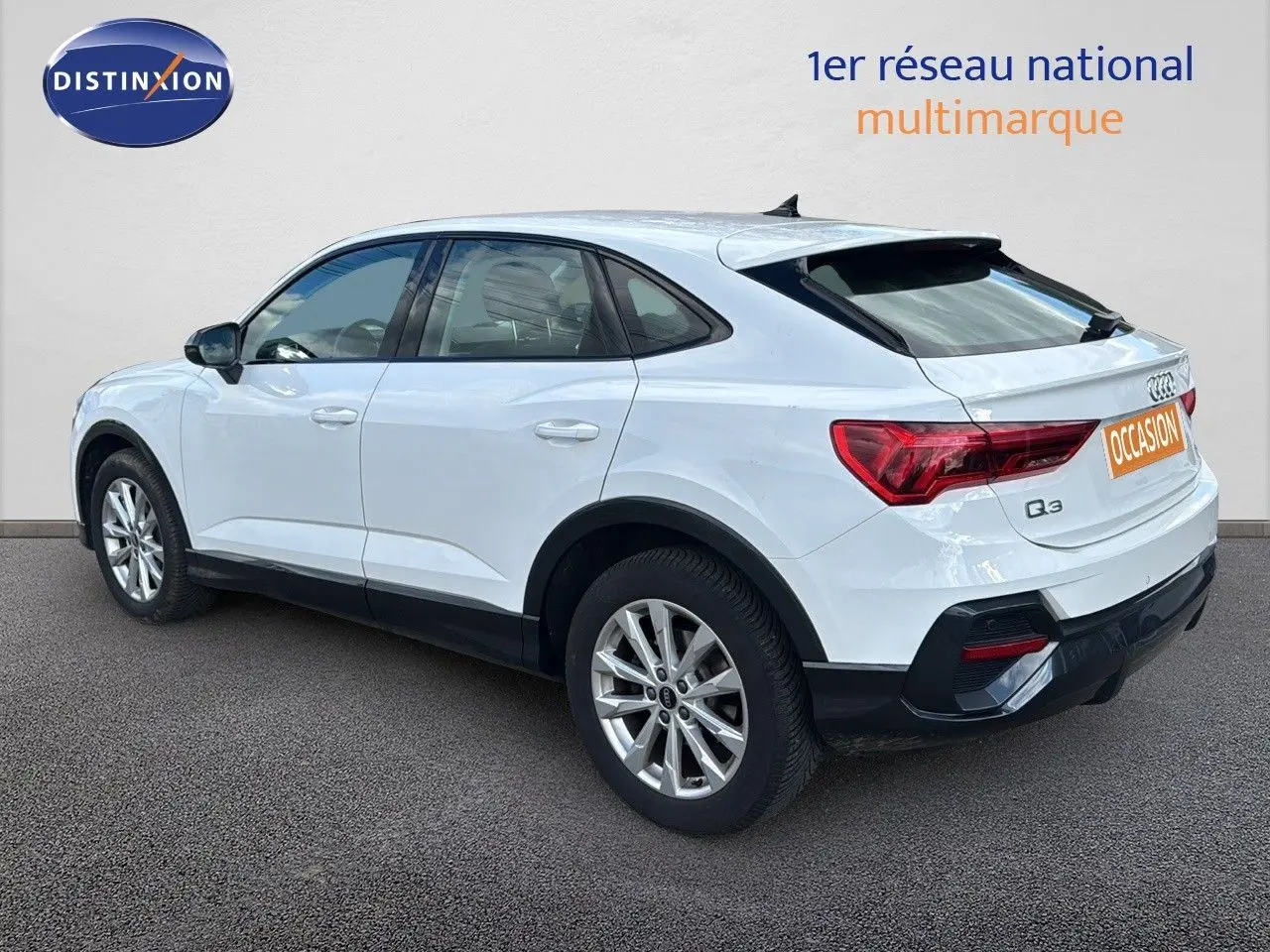 Audi Q3 Sportback blanc vu de trois quarts arrière côté gauche, avec jantes alliage et feux arrière LED.