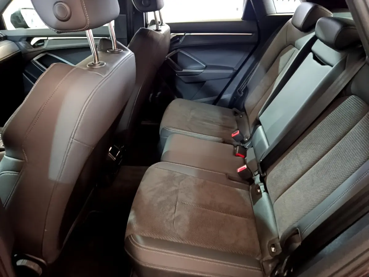 Vue intérieure côté droit montrant la banquette arrière en tissu et cuir gris foncé de l'Audi Q3 35 TFSI S Line 2022.