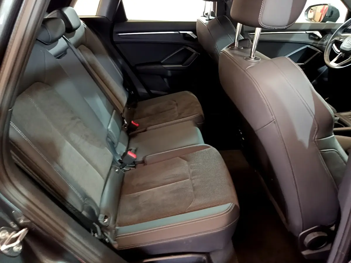 Vue intérieure côté gauche des sièges arrière en tissu et cuir gris foncé de l’Audi Q3 35 TFSI S Line 2022.