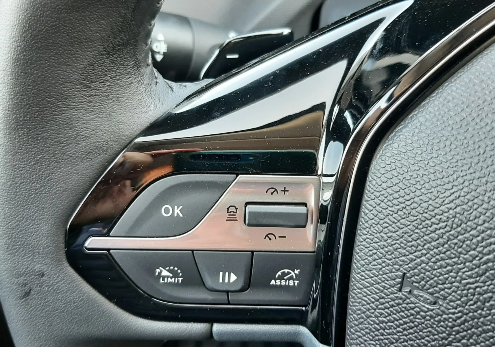 Détail des commandes de réglage manuel du siège avant en tissu noir du Peugeot 308 Bleu Obsession, vue latérale intérieure.