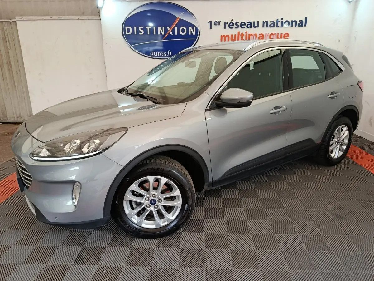 Vue 3/4 avant droite d'un Ford Kuga gris foncé 2023 avec jantes alliage et rétroviseurs assortis.