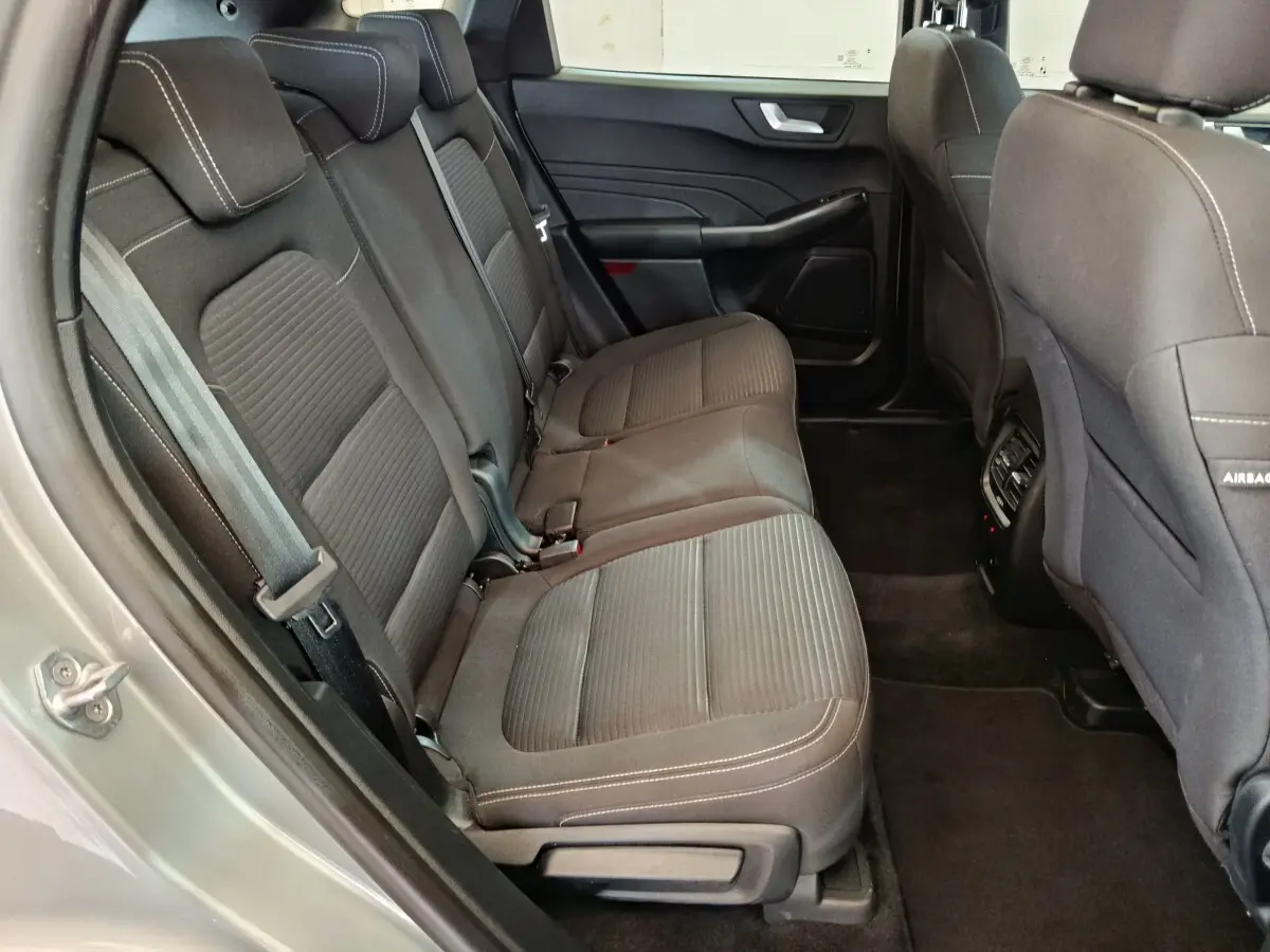 Vue intérieure côté gauche des sièges arrière en tissu gris foncé du Ford Kuga 2023 version hybride Titanium.