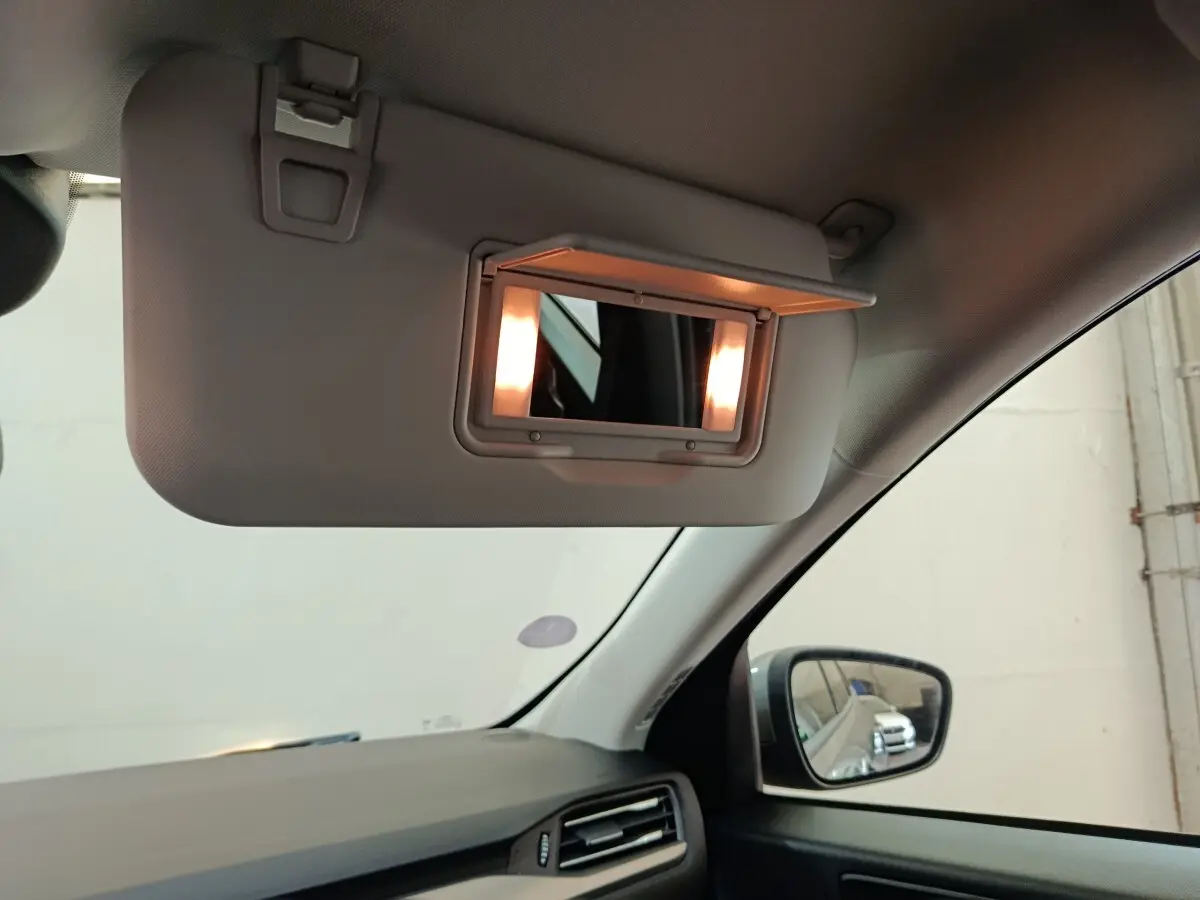 Détail intérieur du pare-soleil avec miroir éclairé côté conducteur du Ford Kuga gris foncé 2023.