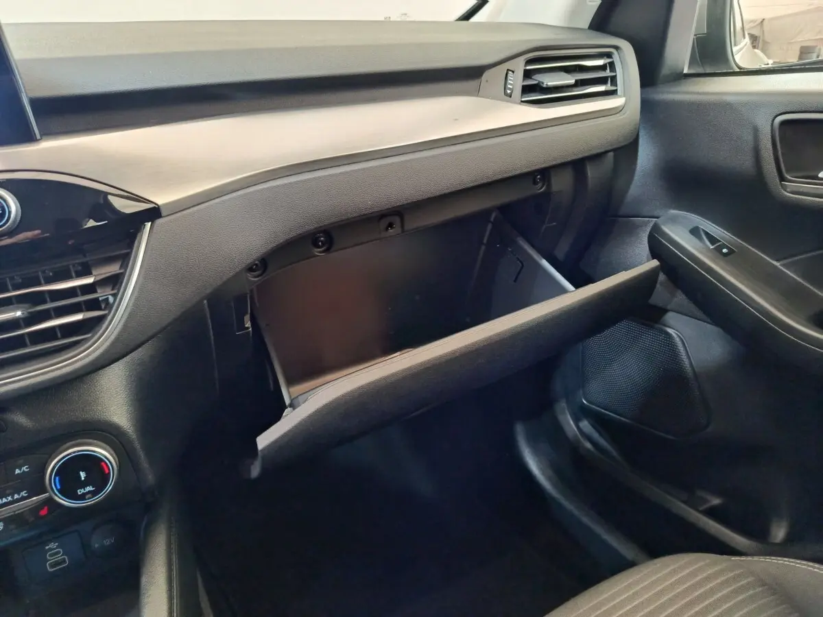Vue intérieure côté passager du tableau de bord noir et gris avec boîte à gants ouverte du Ford Kuga 2023.