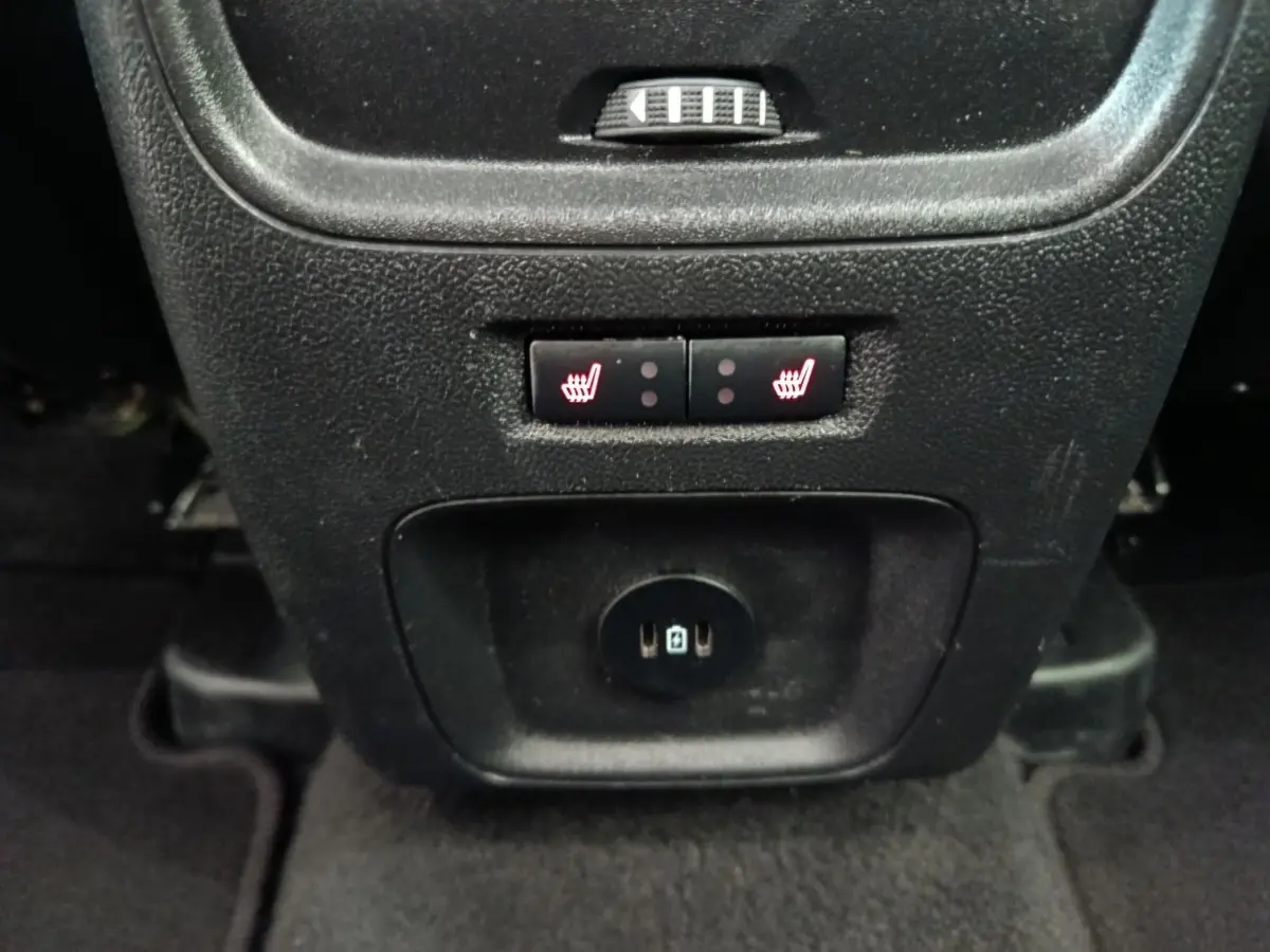 Gros plan sur les commandes de sièges chauffants arrière et prises USB du Ford Kuga gris foncé 2023, console centrale arrière.
