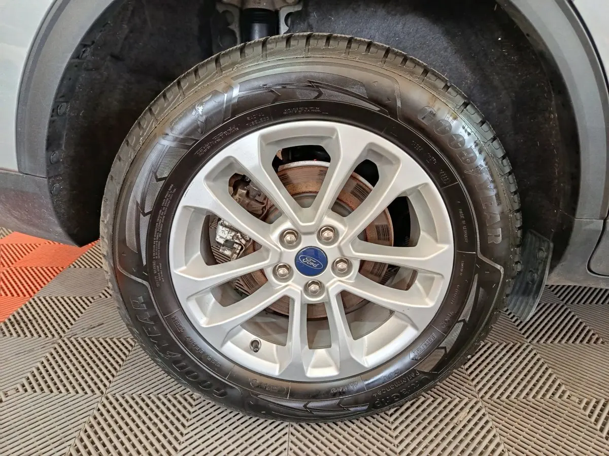Gros plan sur la roue avant droite du Ford Kuga gris foncé, mettant en valeur la jante alliage et le pneu Goodyear.
