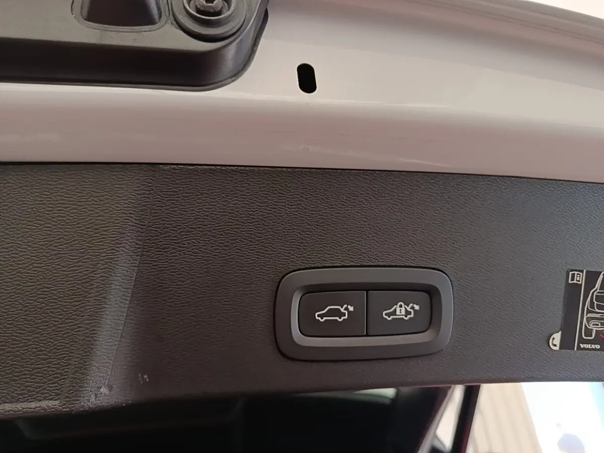 Gros plan sur les boutons d'ouverture et de verrouillage du coffre électrique du Volvo XC40 gris clair, vue intérieure du hayon.