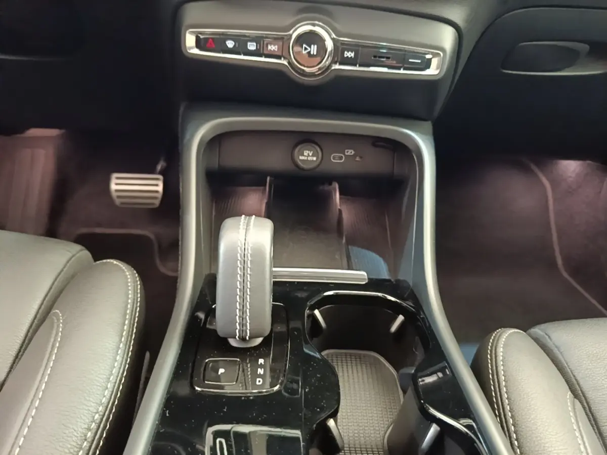 Vue rapprochée de la console centrale du Volvo XC40 P8 R-Design 2021, avec levier de vitesse et commandes audio.