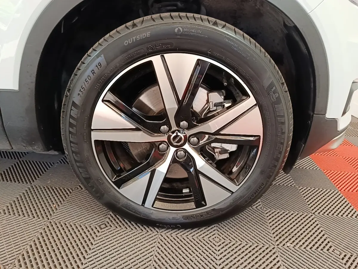 Gros plan sur la roue avant droite du Volvo XC40 P8 gris clair, jante alliage bicolore et pneu Michelin visible.