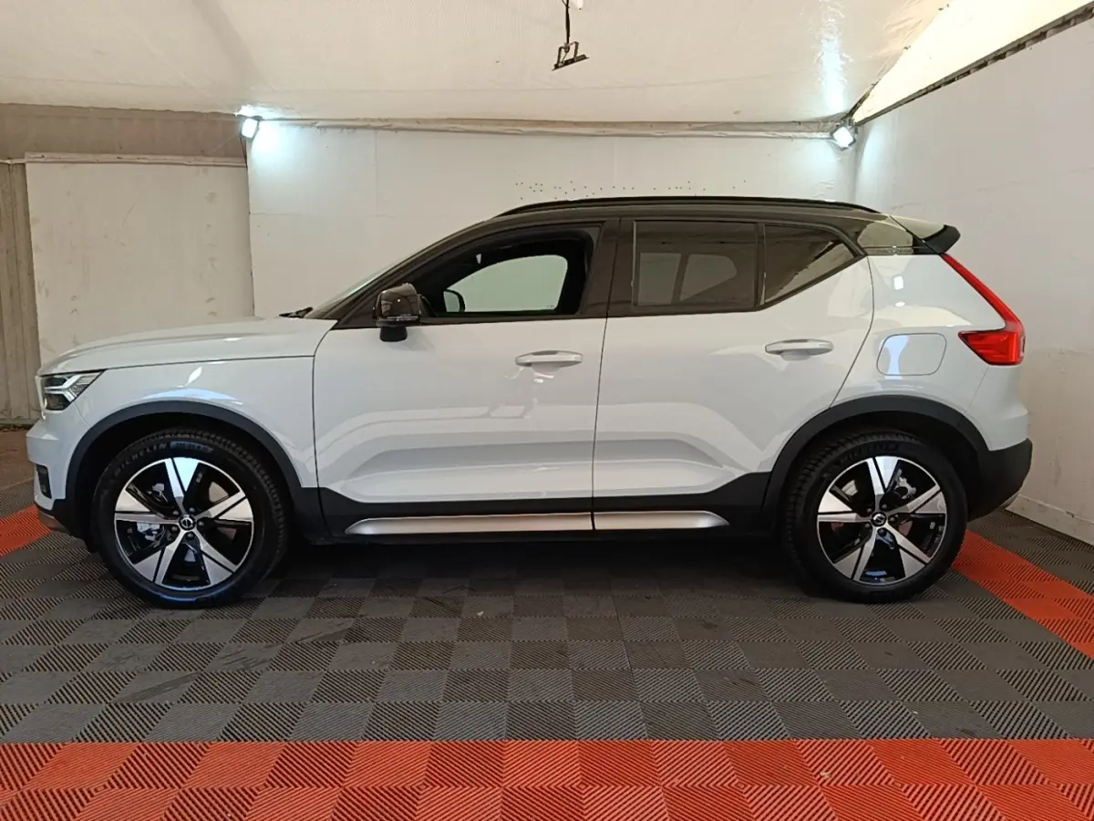 Vue latérale gauche d'un Volvo XC40 P8 gris clair avec toit noir et jantes alliage bicolores en intérieur.