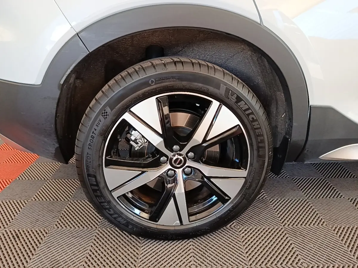 Gros plan sur la roue arrière droite du Volvo XC40 gris clair avec jante alliage bicolore et pneu Michelin.