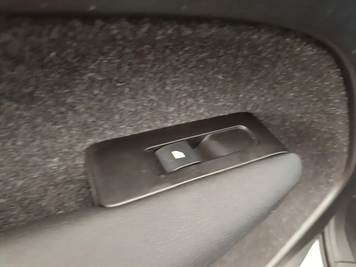 Gros plan sur l'interrupteur de verrouillage des vitres arrière dans un Volvo XC40 gris clair électrique.