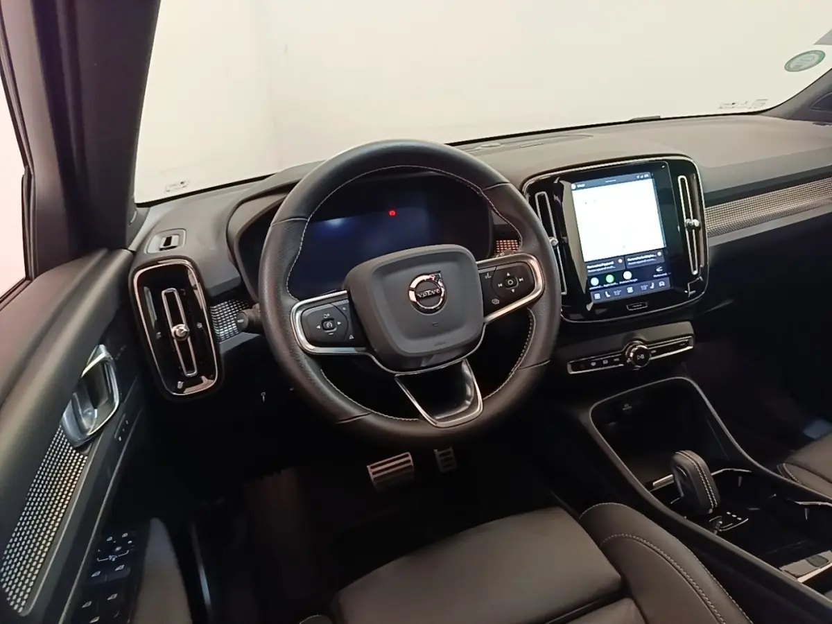 Intérieur noir du Volvo XC40 P8 408 R-Design 2021, vue centrée sur le volant et l’écran tactile vertical du tableau de bord.