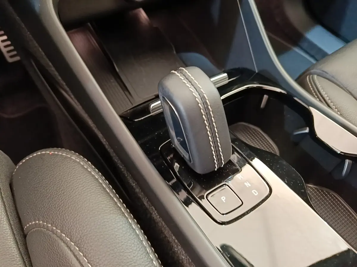 Gros plan sur la console centrale noire et le levier de vitesse cuir gris clair du Volvo XC40 P8 électrique 2021.