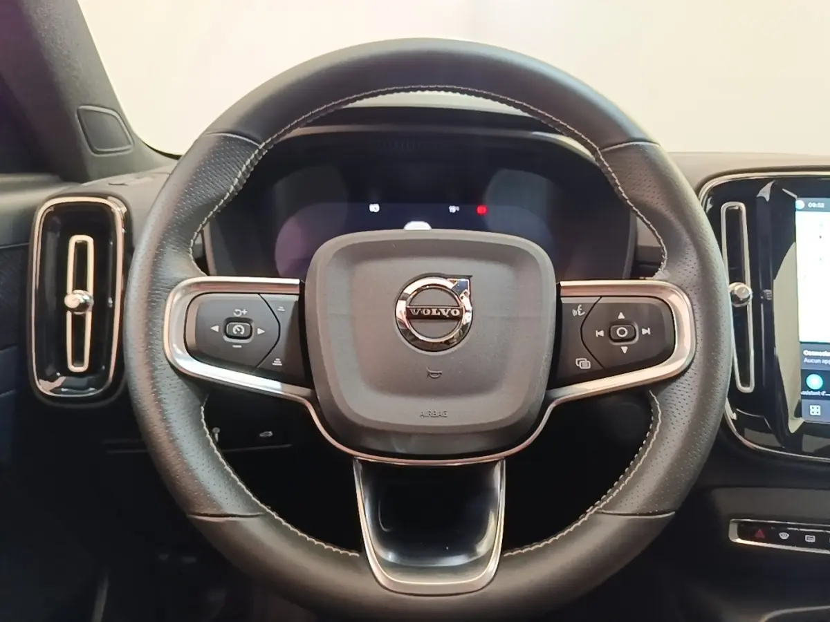 Volant cuir noir avec surpiqûres blanches de Volvo XC40 P8 R-Design, vue frontale centrée sur le logo.