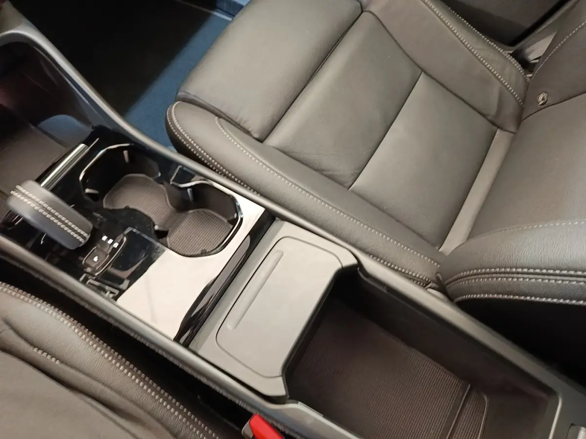 Vue rapprochée de la console centrale et siège en cuir gris foncé du Volvo XC40 P8 R-Design 2021, avec levier de vitesse.
