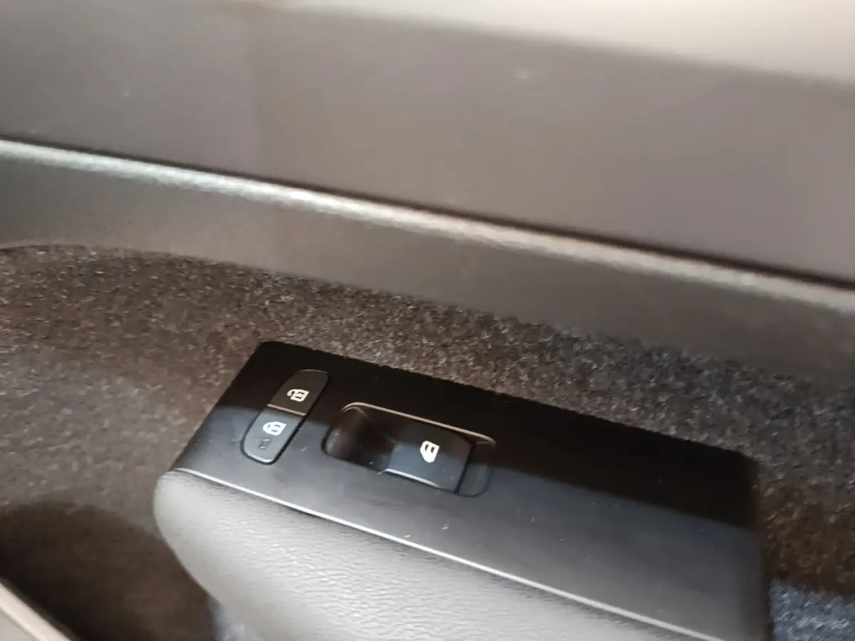 Gros plan sur les commandes de verrouillage des portes dans l'habitacle du Volvo XC40 gris clair.
