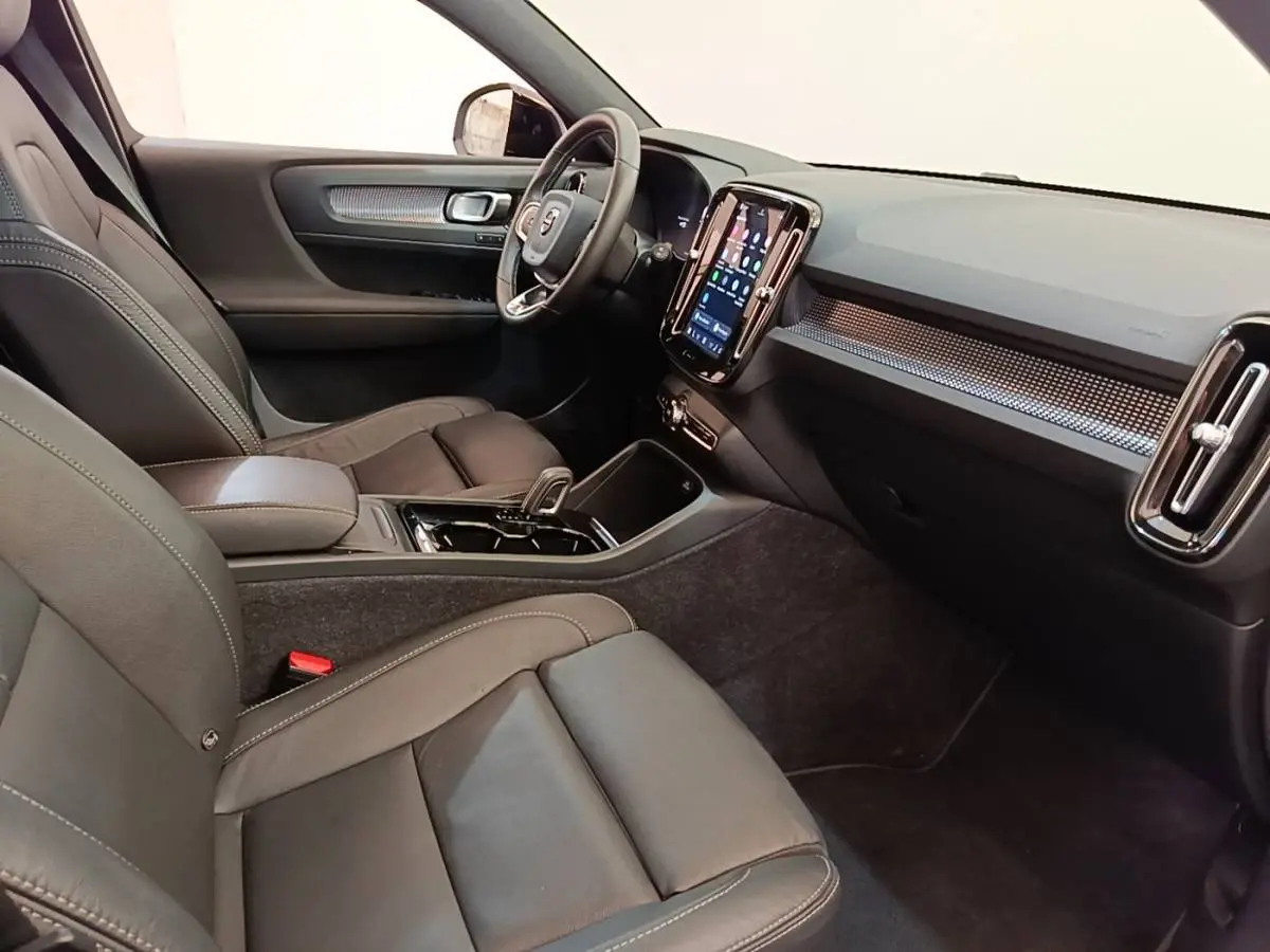 Vue intérieure côté conducteur du Volvo XC40 P8 408 R-Design 2021, montrant sièges cuir noirs et écran tactile vertical.