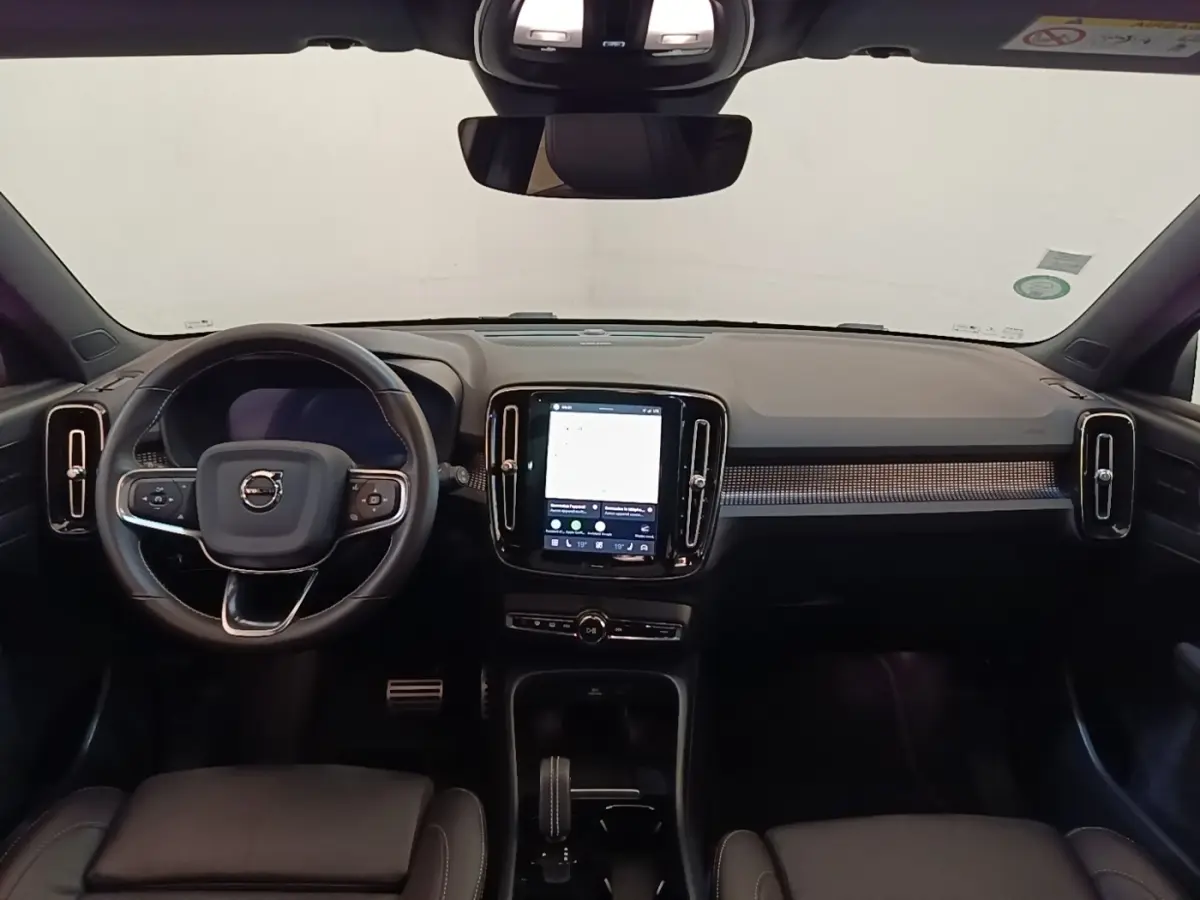 Vue intérieure frontale du tableau de bord noir du Volvo XC40 P8 408 R-Design avec écran tactile central vertical.
