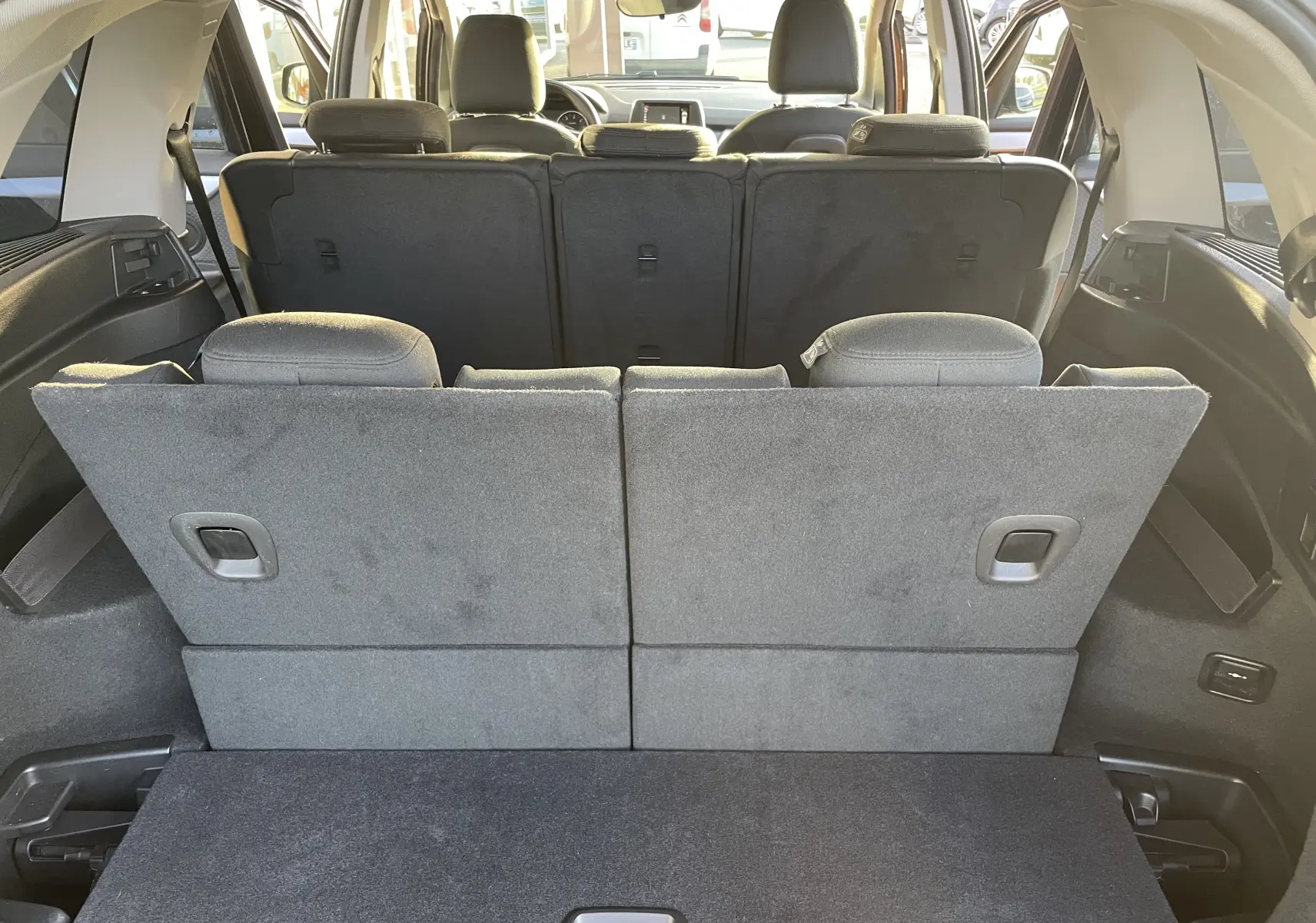 Vue arrière du coffre avec la troisième rangée de sièges relevée d'une BMW Série 2 Gran Tourer F46 noire de 2017.