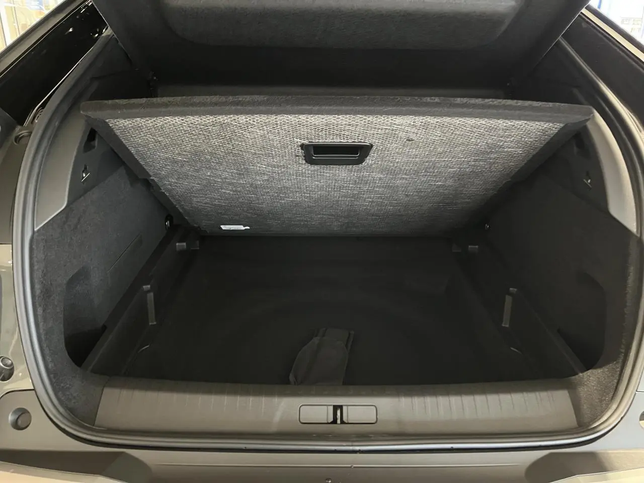 Coffre ouvert du Peugeot 3008 gris titanium, vue arrière mettant en valeur l'espace de rangement modulable.