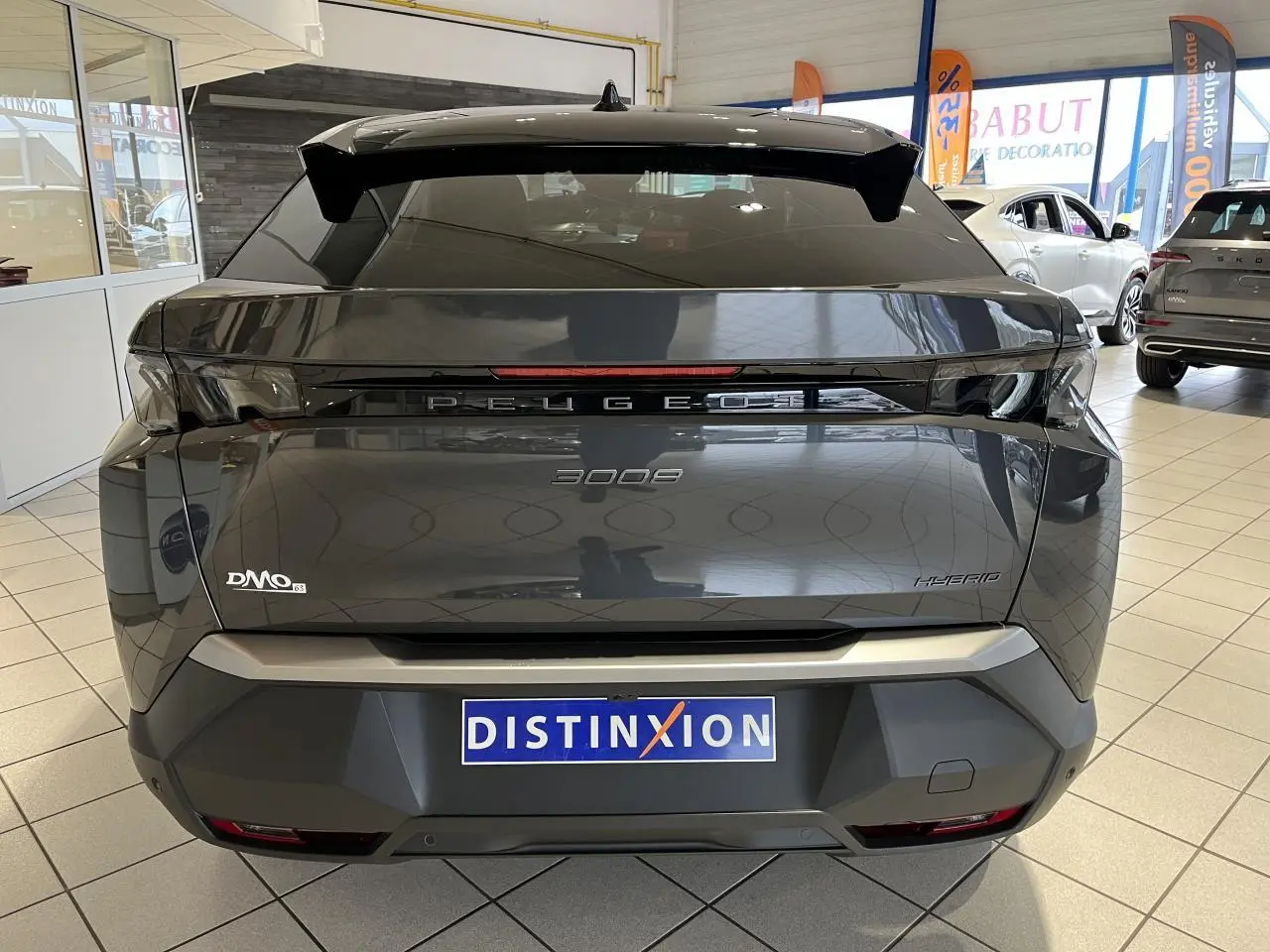 Vue arrière d'un Peugeot 3008 gris titanium 2025 avec bandeau noir laqué et feux arrière à griffes LED 3D.