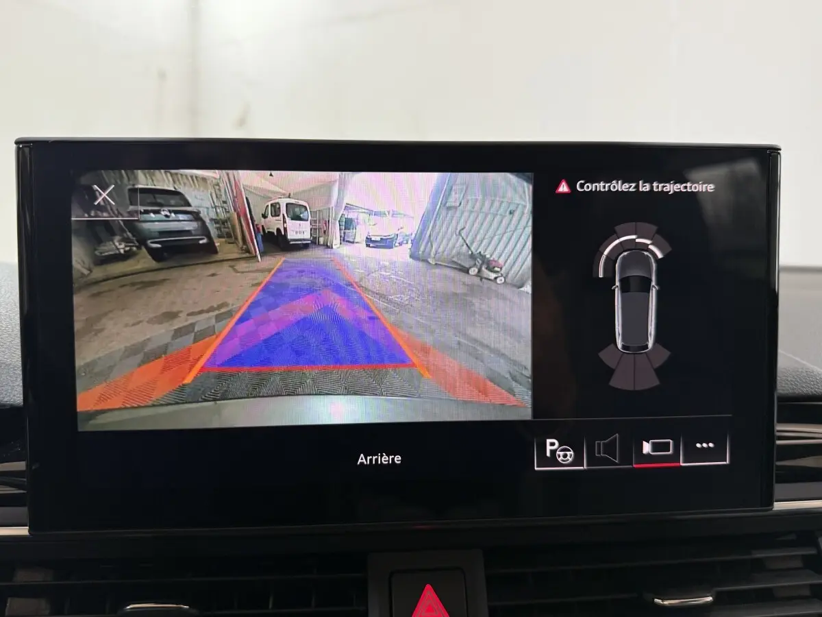 Écran intérieur affichant la caméra de recul et l'aide au stationnement de l'Audi A4 gris foncé, vue arrière.