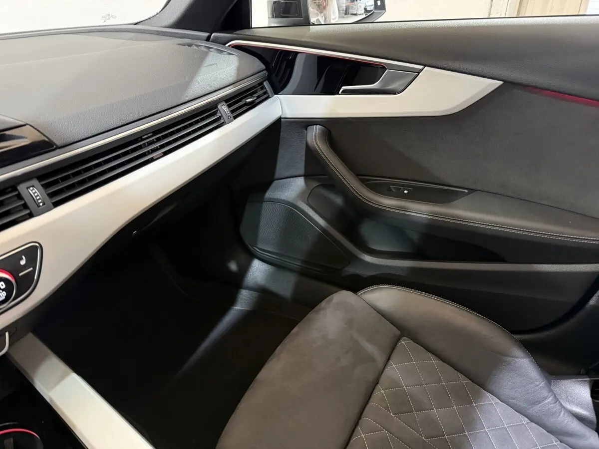 Vue intérieure côté passager de l'Audi A4 35 TFSI 2022, avec sellerie cuir gris et tableau de bord clair.