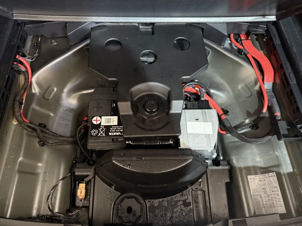 Vue plongeante sur le compartiment batterie gris métallique avec câbles rouges de l'Audi A4 35 TFSI hybride 2022.