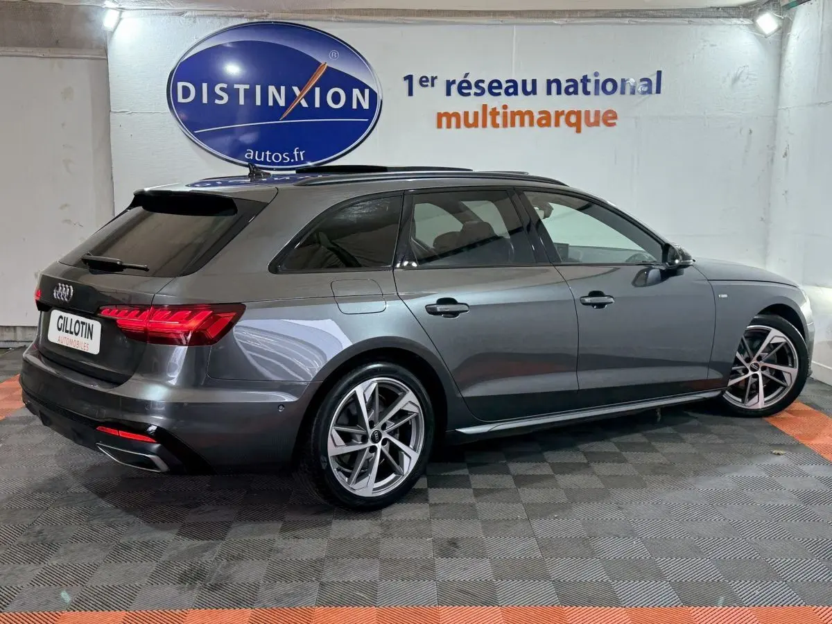 Audi A4 35 TFSI S Edition gris foncé vue 3/4 arrière droit, avec jantes alliage et feux LED allumés.
