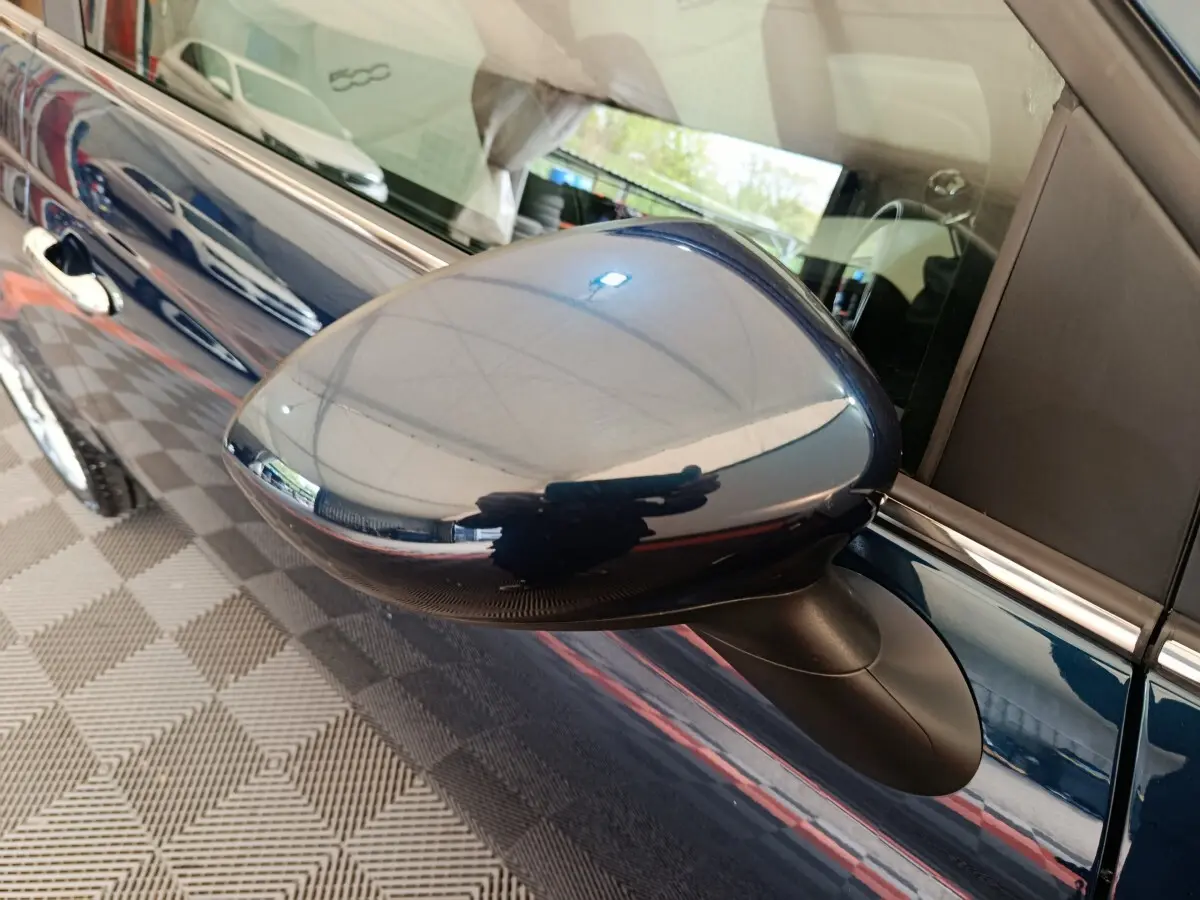 Rétroviseur côté gauche bleu brillant de la Fiat 500 Hybrid 2022, avec reflet de l'environnement intérieur.