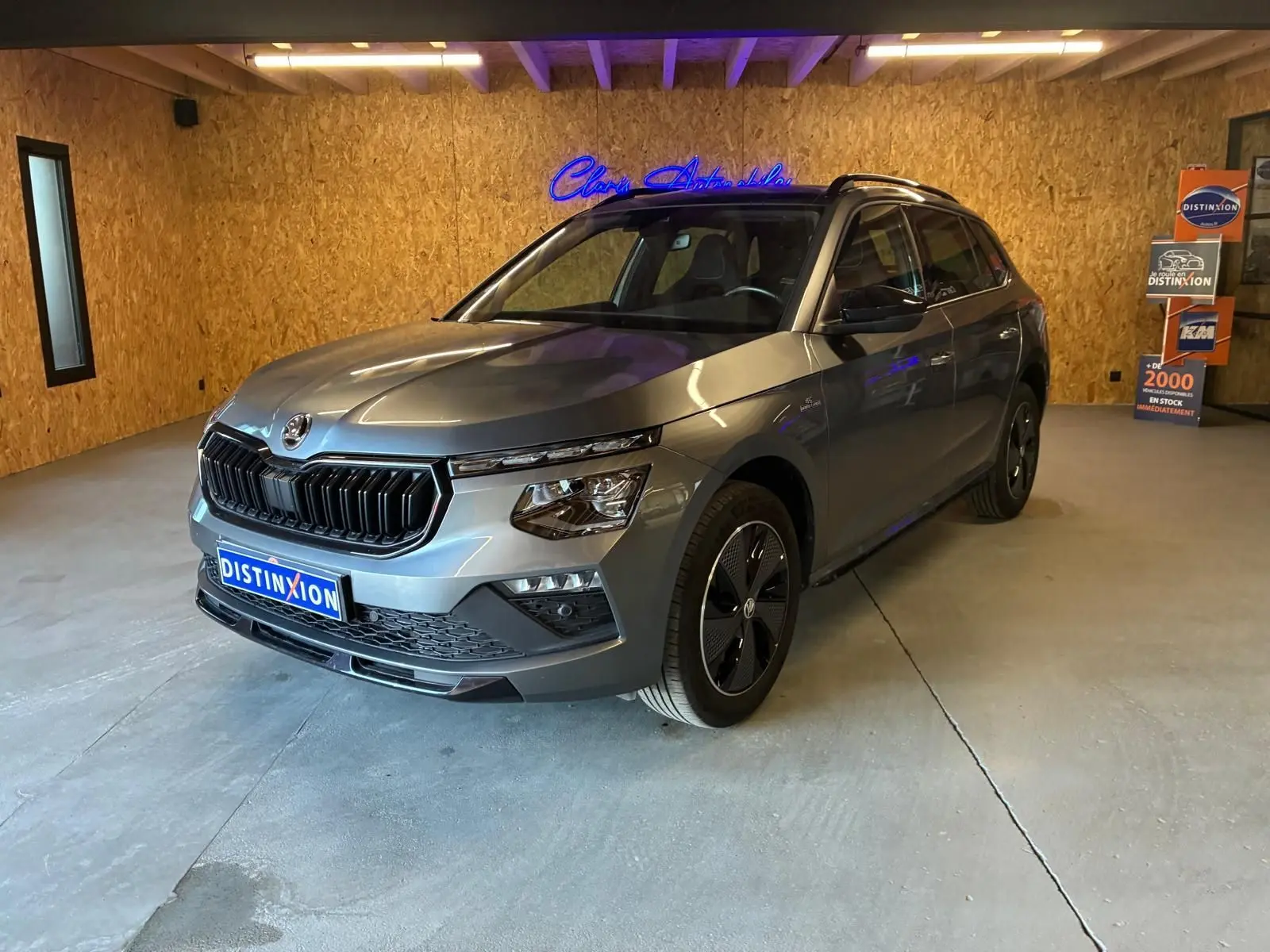 Vue 3/4 avant droite du Skoda Kamiq gris foncé 2024 avec calandre noire et jantes spécifiques Monte-Carlo.