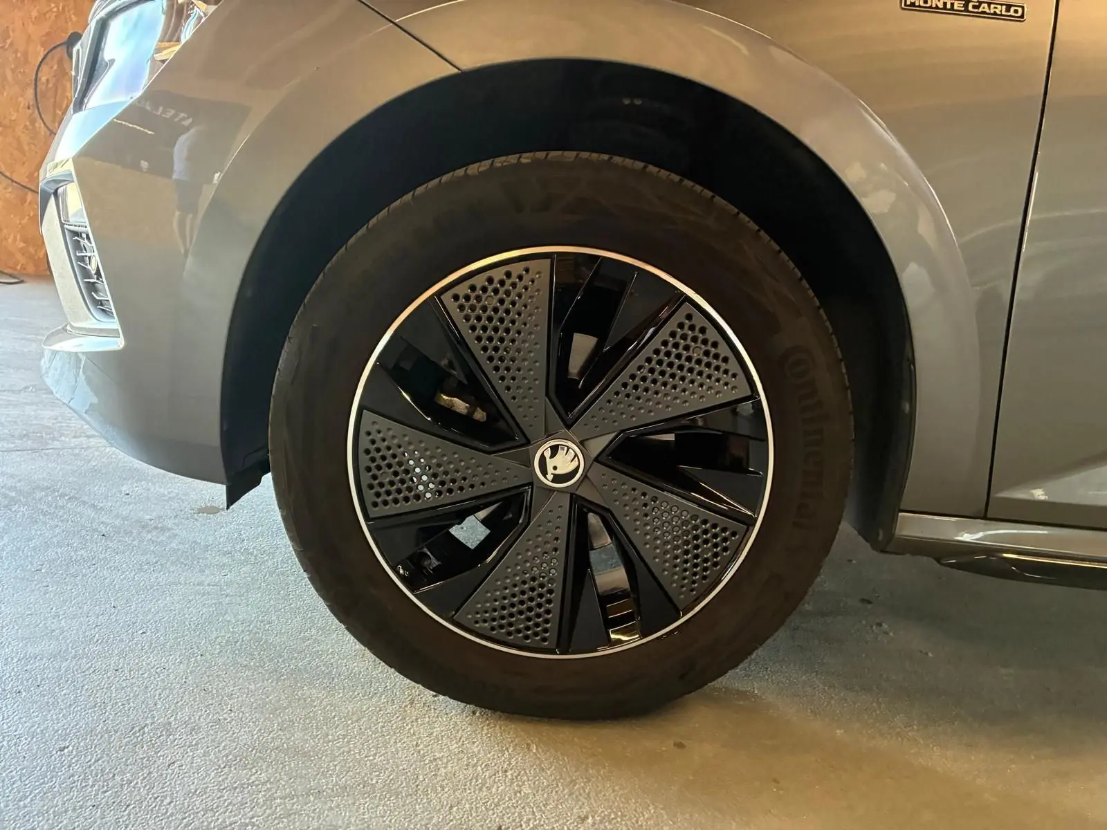 Gros plan sur la roue avant gauche du Skoda Kamiq gris foncé 2024 avec jante noire et argentée au design moderne.