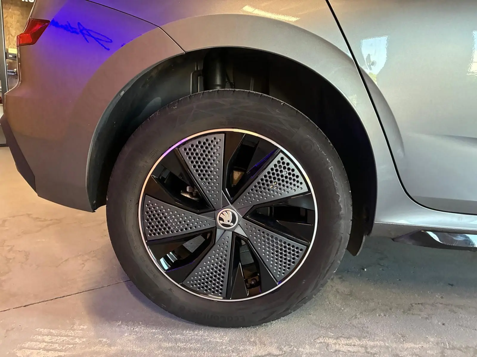 Gros plan sur la roue arrière droite du Skoda Kamiq gris foncé 2024, mettant en valeur la jante au design moderne bicolore.