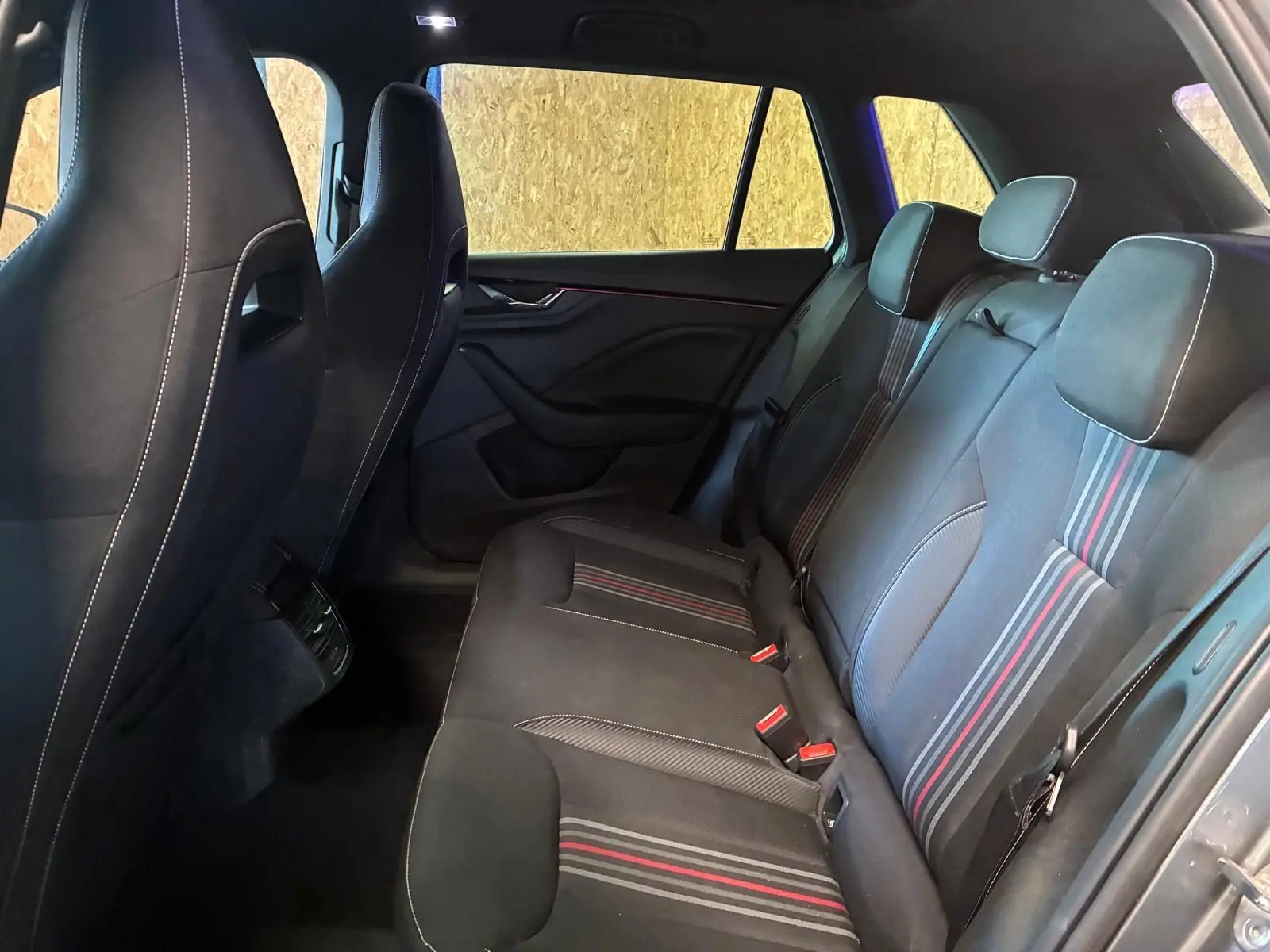 Vue intérieure côté droit des sièges arrière en tissu noir avec surpiqûres rouges et grises du Skoda Kamiq 2024 Monte-Carlo.