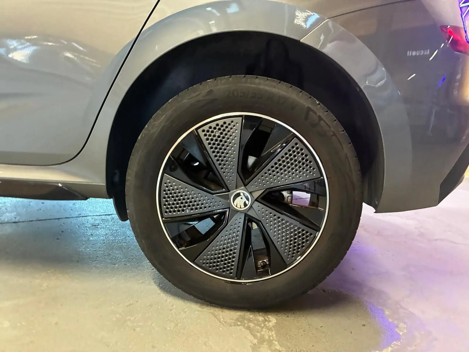 Gros plan sur la roue arrière droite du Skoda Kamiq gris foncé 2024 avec jante au design moderne bicolore.