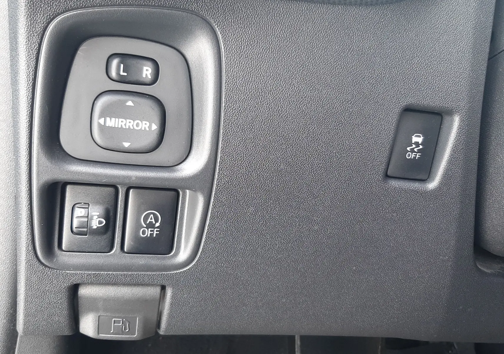Gros plan sur les commandes noires côté gauche du tableau de bord d'une Citroën C1 gris foncé, version Shine 2019.