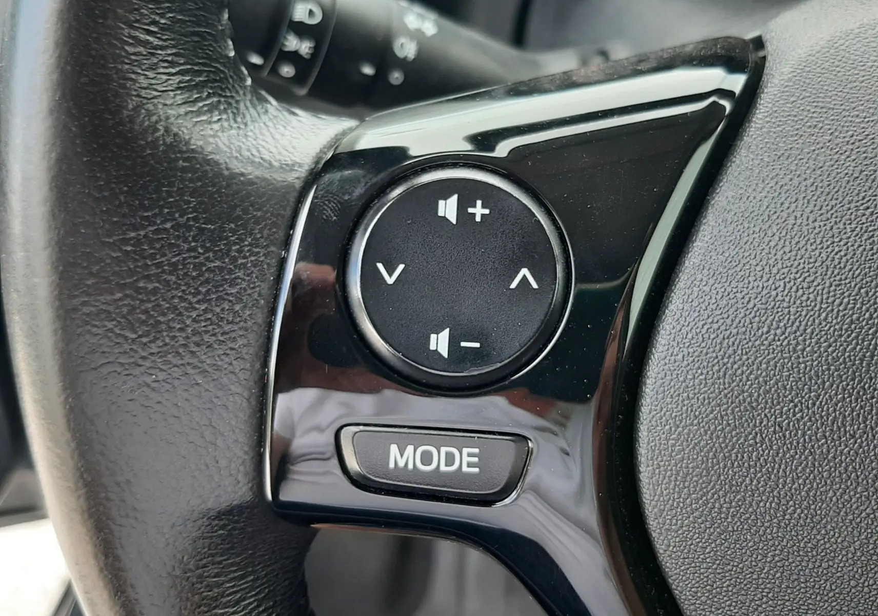 Gros plan sur les commandes audio noires intégrées au volant en cuir de la Citroën C1 gris foncé 2019.