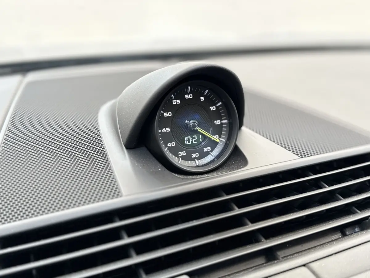 Gros plan sur l'horloge analogique noire intégrée au tableau de bord de la Porsche Panamera 4 E-Hybrid Sport Turismo.