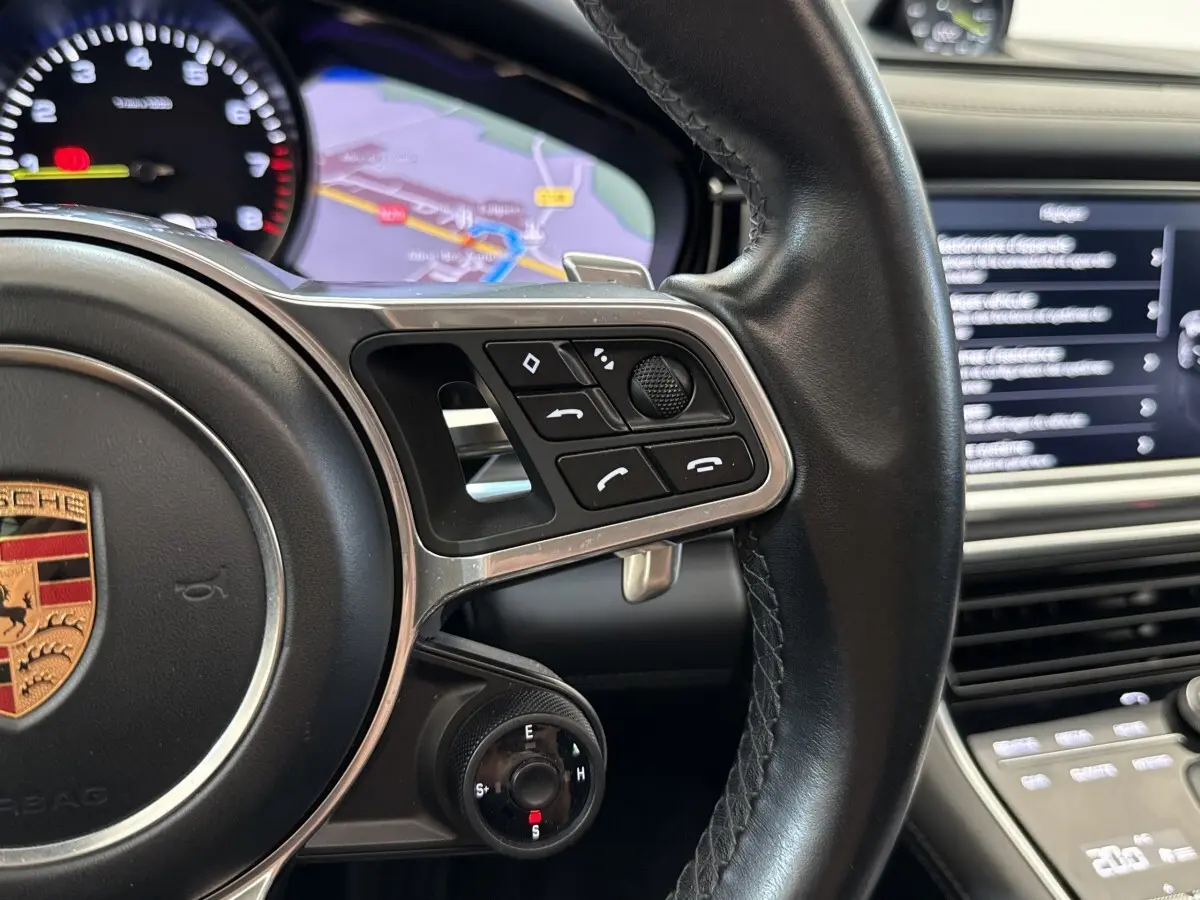 Gros plan sur le volant cuir noir multifonctions de la Porsche Panamera 4 E-Hybrid avec écran tactile et navigation visible.
