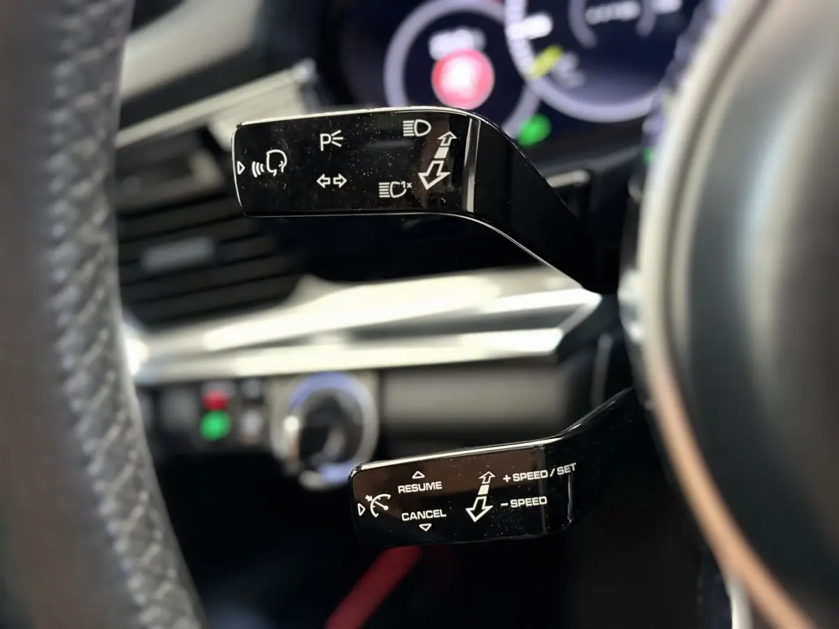 Gros plan sur les commandes au volant noir de la Porsche Panamera 4 E-Hybrid Sport Turismo 2018, intérieur moderne.