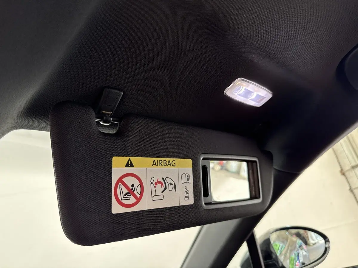 Détail du pare-soleil côté conducteur avec miroir intégré et éclairage intérieur allumé dans une Porsche Panamera 4 E-Hybrid noire.