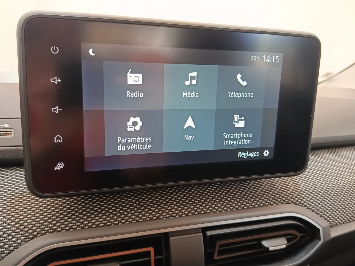 Écran tactile central affichant les options multimédia et navigation dans l'habitacle d'une Dacia Sandero gris clair.