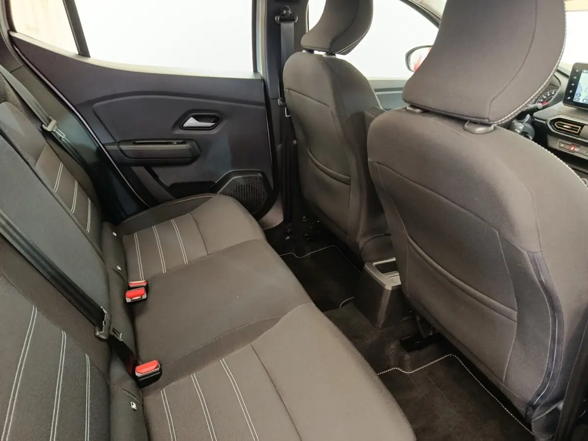 Vue intérieure arrière côté gauche de la banquette noire avec surpiqûres blanches de la Dacia Sandero Expression 2023.