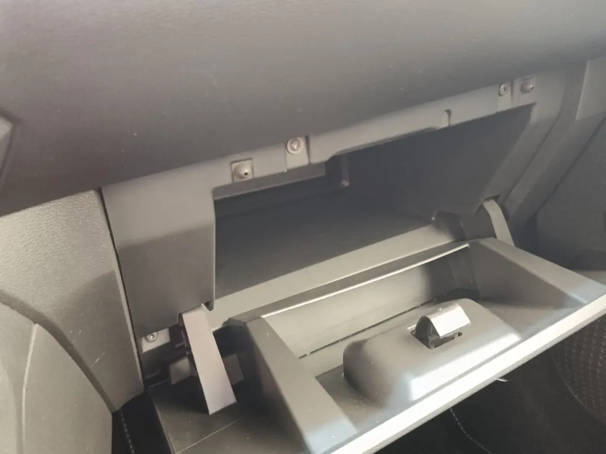 Gros plan sur la boîte à gants ouverte côté passager de la Dacia Sandero Expression gris clair 2023.