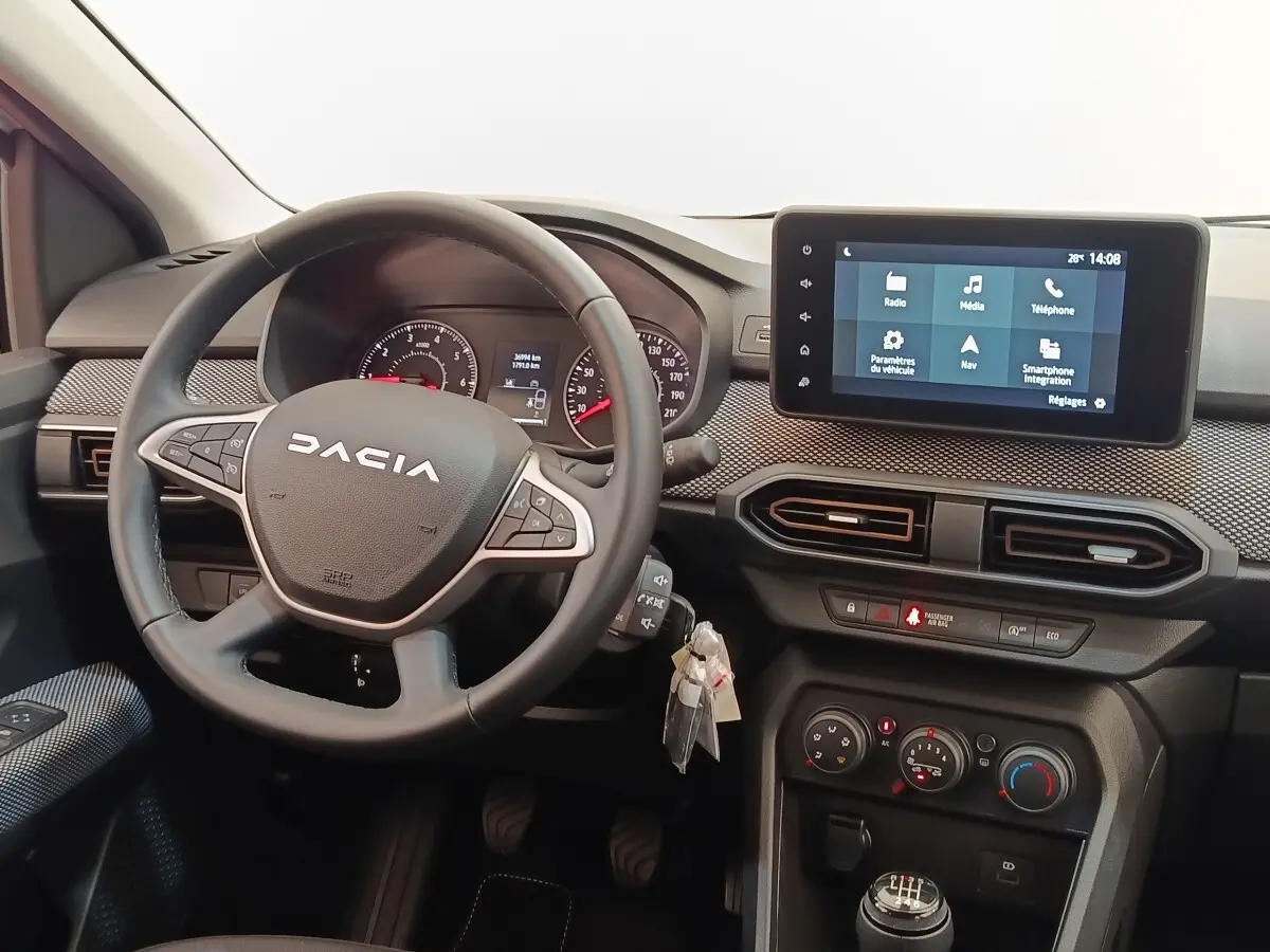 Vue intérieure du tableau de bord de la Dacia Sandero gris clair, volant cuir multifonctions et écran tactile central.