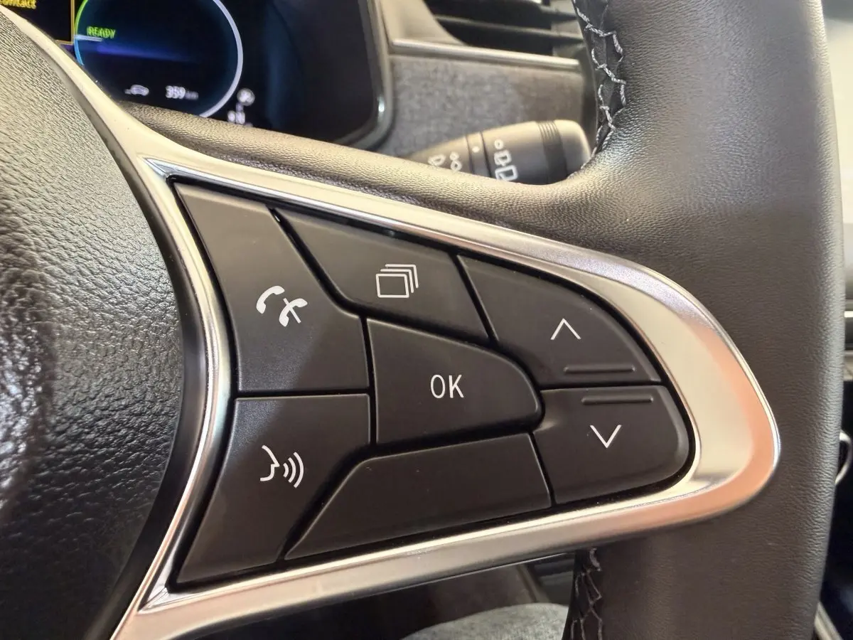 Gros plan sur les commandes multifonctions du volant cuir noir de la Renault ZOE électrique 2024.