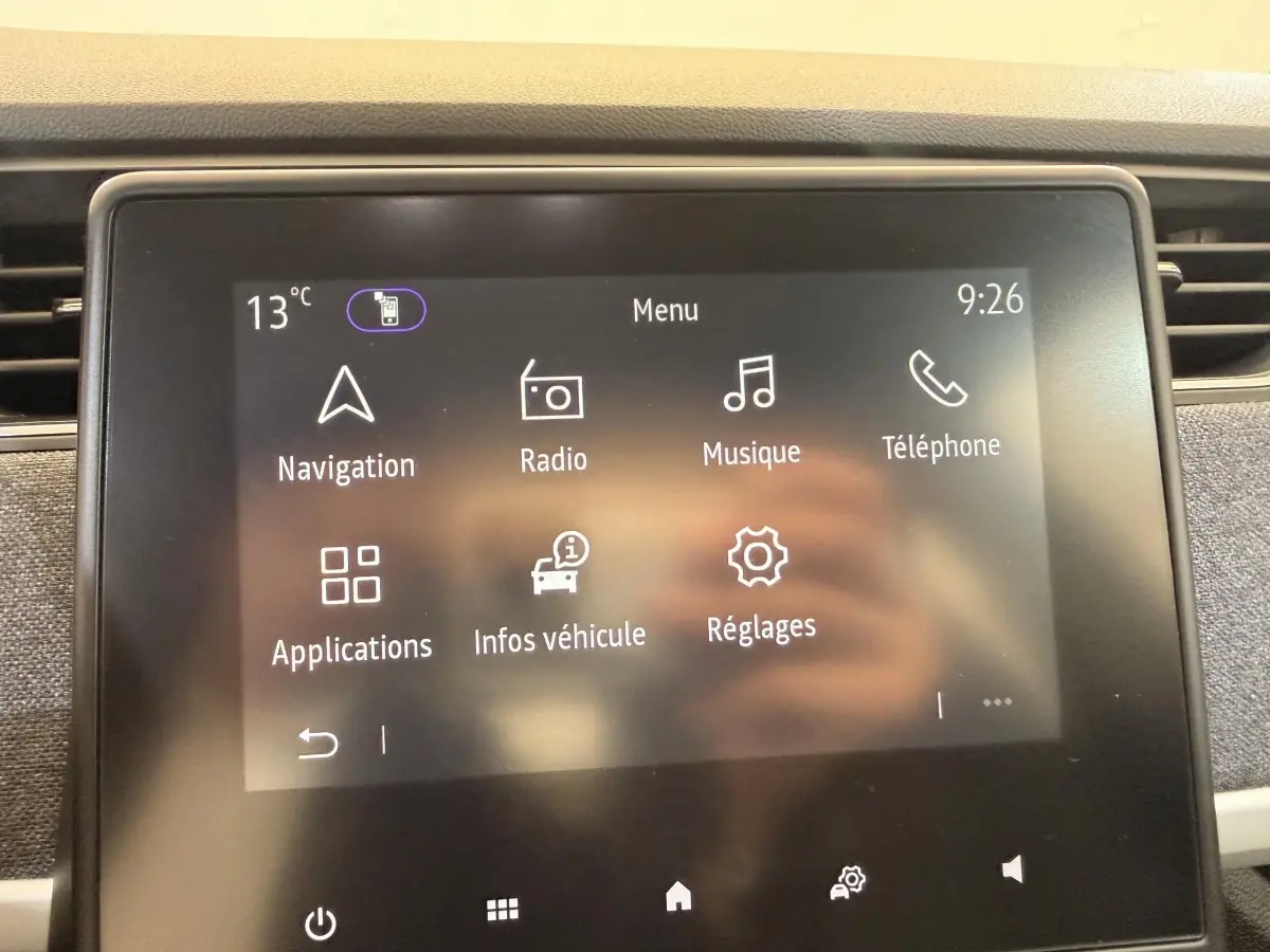 Écran tactile central de la Renault ZOE noire 2024 affichant le menu principal avec options navigation, radio et téléphone.