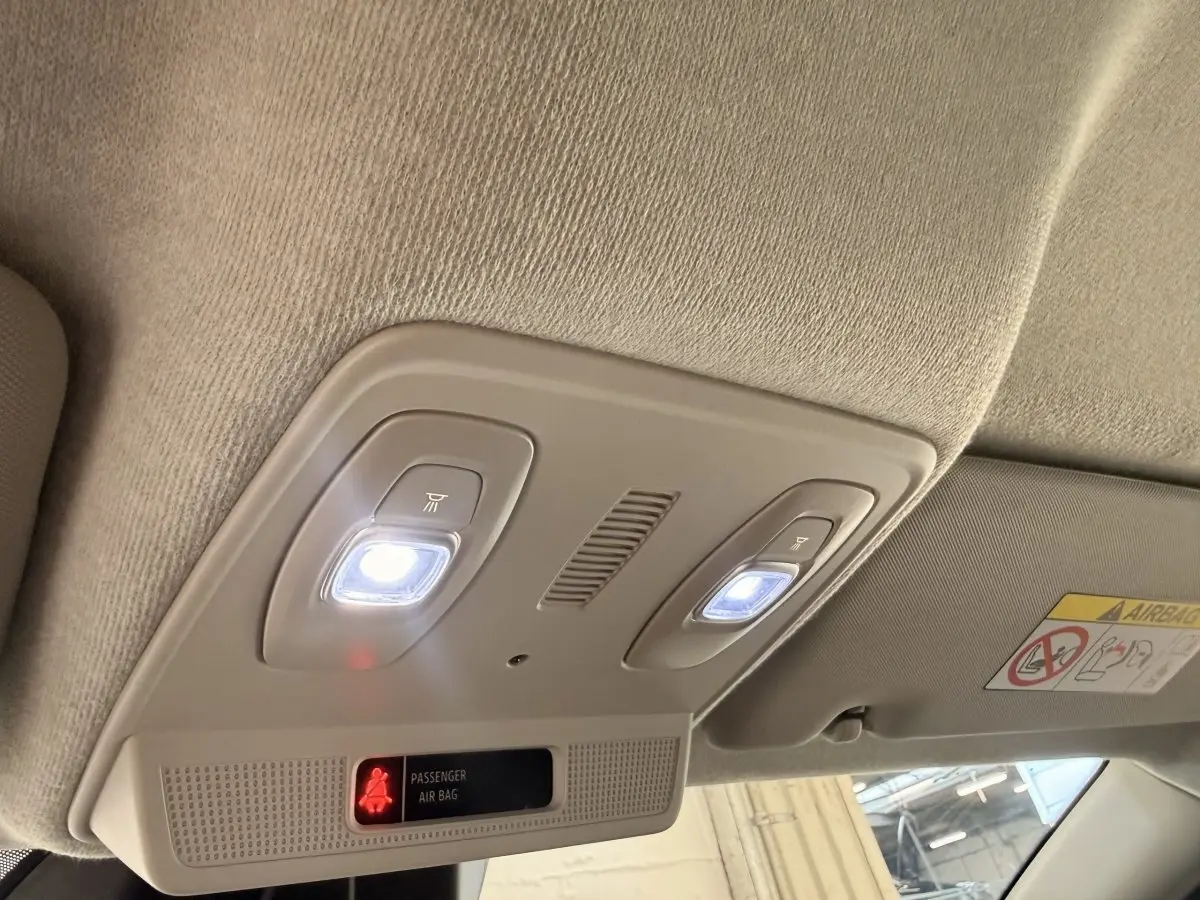 Plafonnier intérieur avec éclairage LED blanc et témoin airbag passager actif dans une Renault ZOE noire.